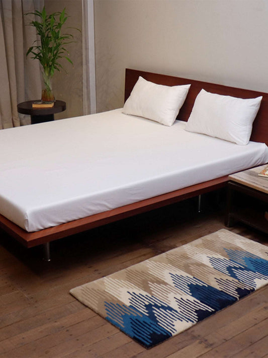 side view of white colored plain soft bedsheet with 2 matching pillow covers made from 100% pure cotton for king size double bed in 300 thread count fabric