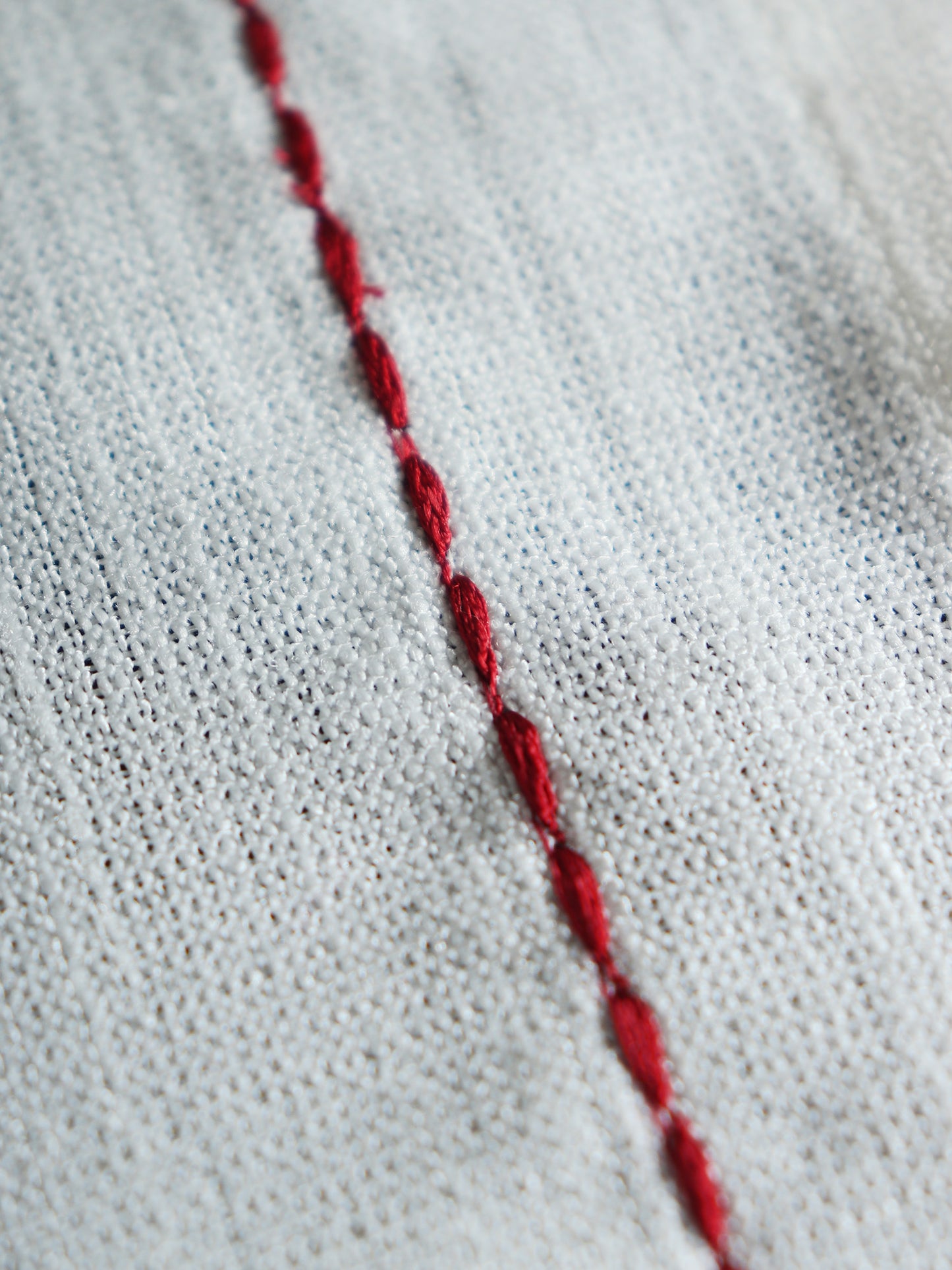 closeup of embroidered dinner table placemats in white and red contrast - 13x19 inch