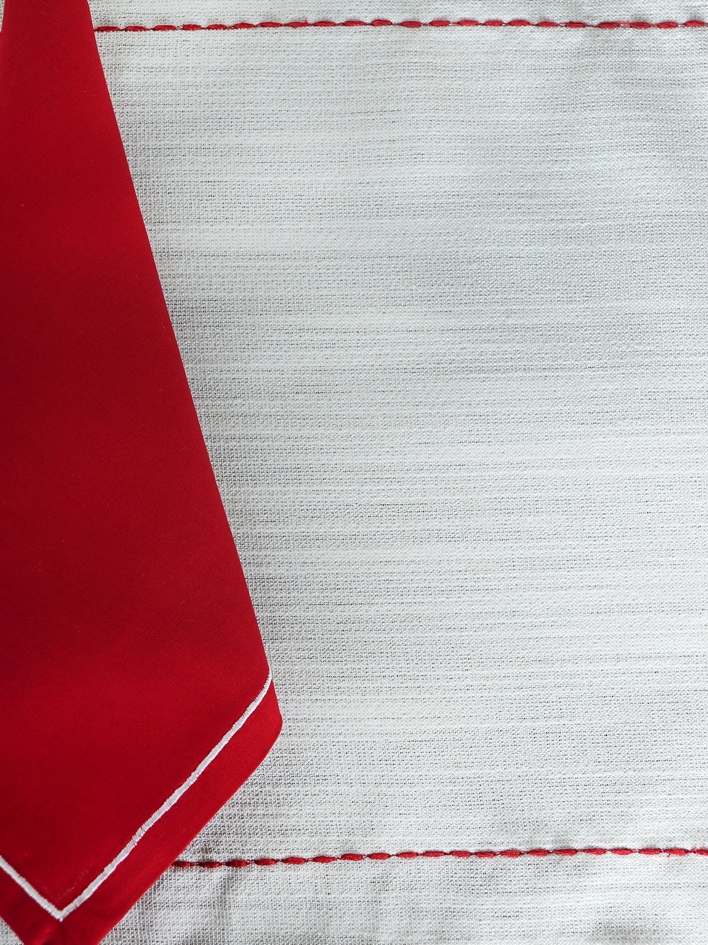 closeup of embroidered dinner table placemats and embroidered napkins in white and red contrast - 13x19 inch