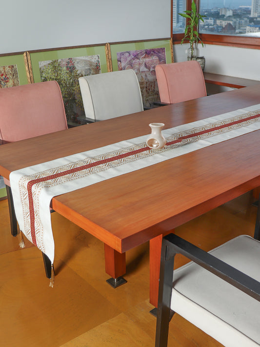 beige colored embroidered table runner with red patch in center and golden embroidery and tassels on corners for 6 seater table - 52x84 inches.