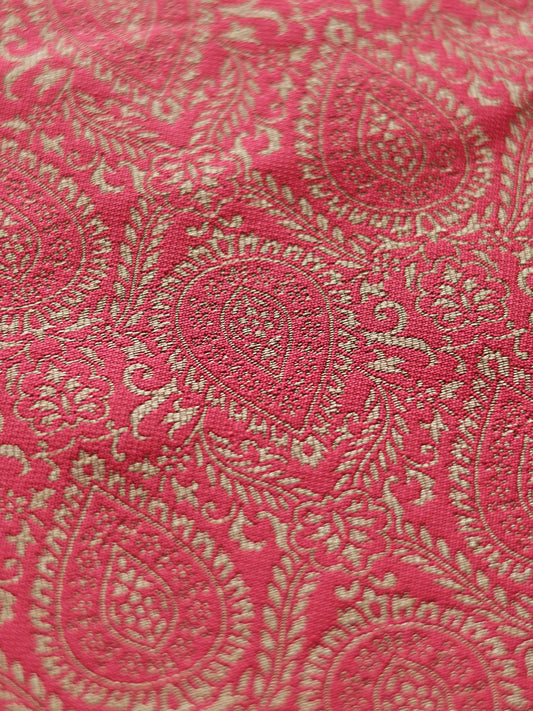 Close-up of pink fabric with gold paisley pattern