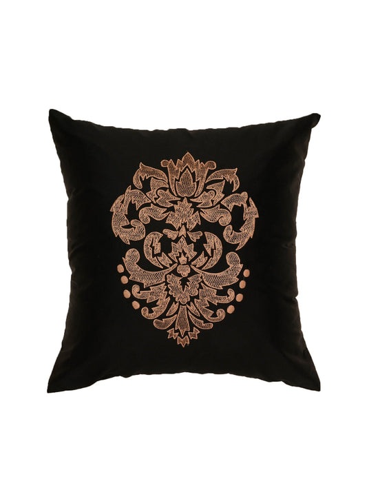 Black pillow with gold decorative pattern on a white background