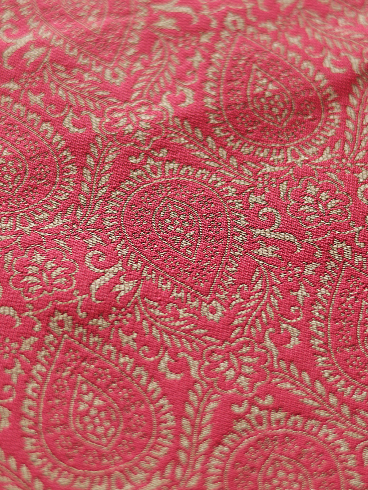 Close-up of pink fabric with gold paisley pattern