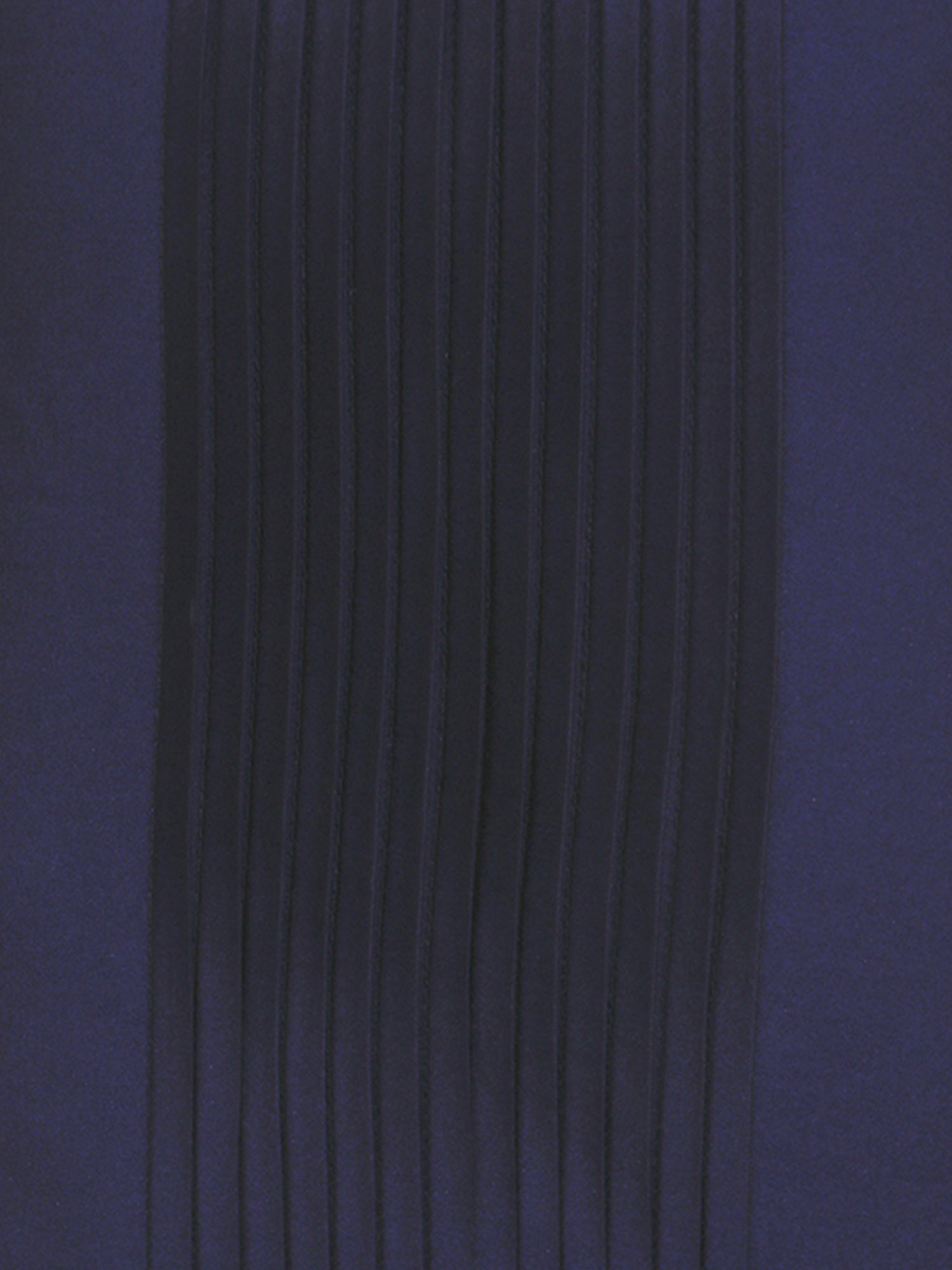 A close-up of dark navy blue pleated fabric with vertical folds on a matching solid navy background.