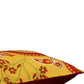 A close-up of a decorative throw pillow featuring a yellow and red paisley pattern with a solid dark red underside, shown against a plain white background.
