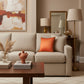 A square orange throw pillow with a textured satin-like finish and a contrasting dark brown sequined border, shown against a plain white background.