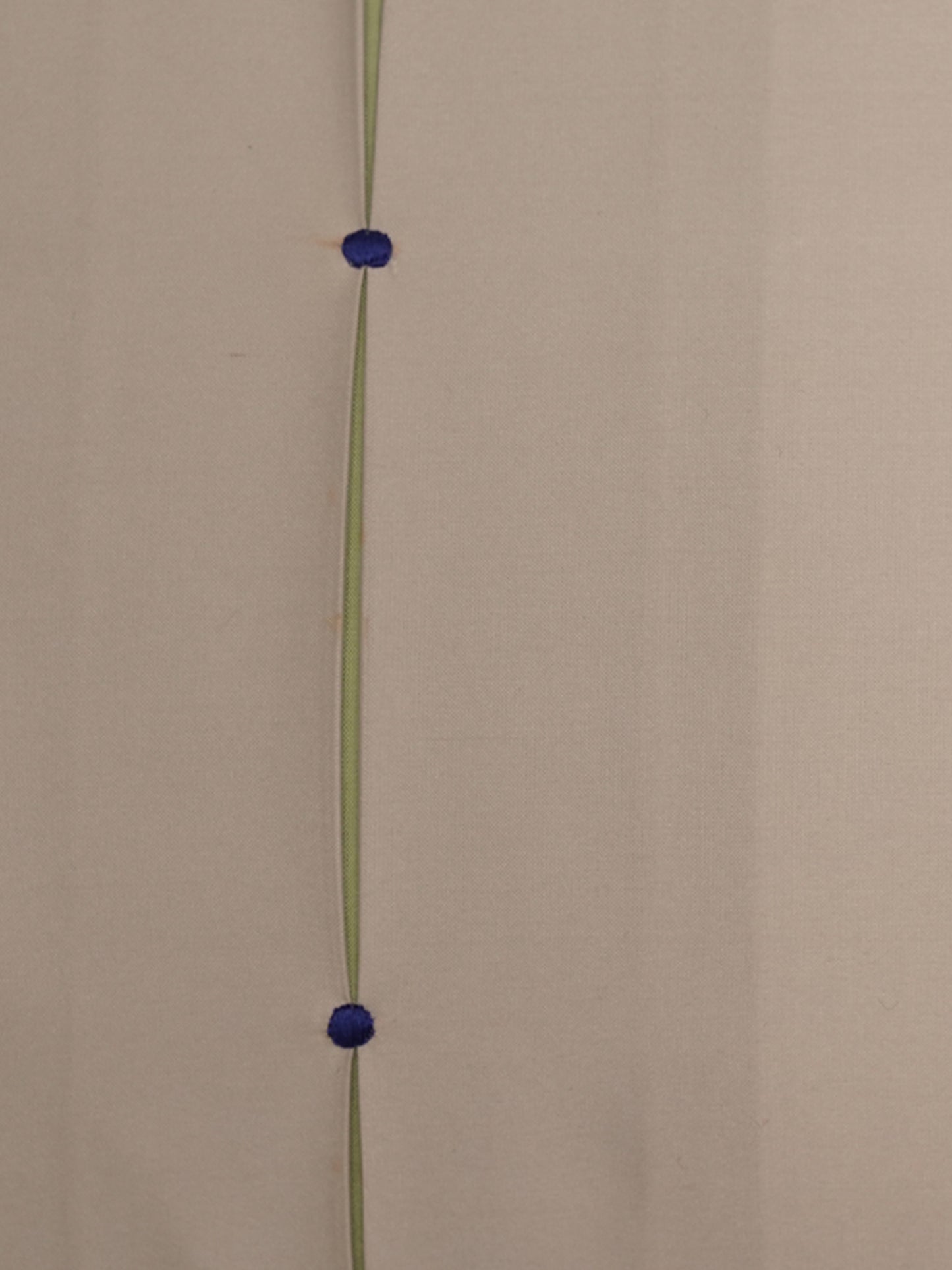 A minimalist wall art piece featuring a vertical olive green line with two small, round, dark blue metallic beads suspended at equal intervals, set against a plain beige wall.