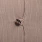 Close-up of a textured fabric surface in a warm taupe-beige color with a single dark brown button near the center.