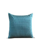 A square teal blue textured throw pillow with white corner ties, shown against a solid black background.