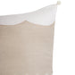 A close-up of a decorative throw pillow featuring a natural beige linen panel with a scalloped edge, bordered by white fabric and finished with a small pom-pom on the corner, set against a plain white background.