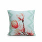 A decorative throw pillow with a pink floral print and mint green chevron border, styled on a blue wooden bench with a matching patterned white throw blanket.